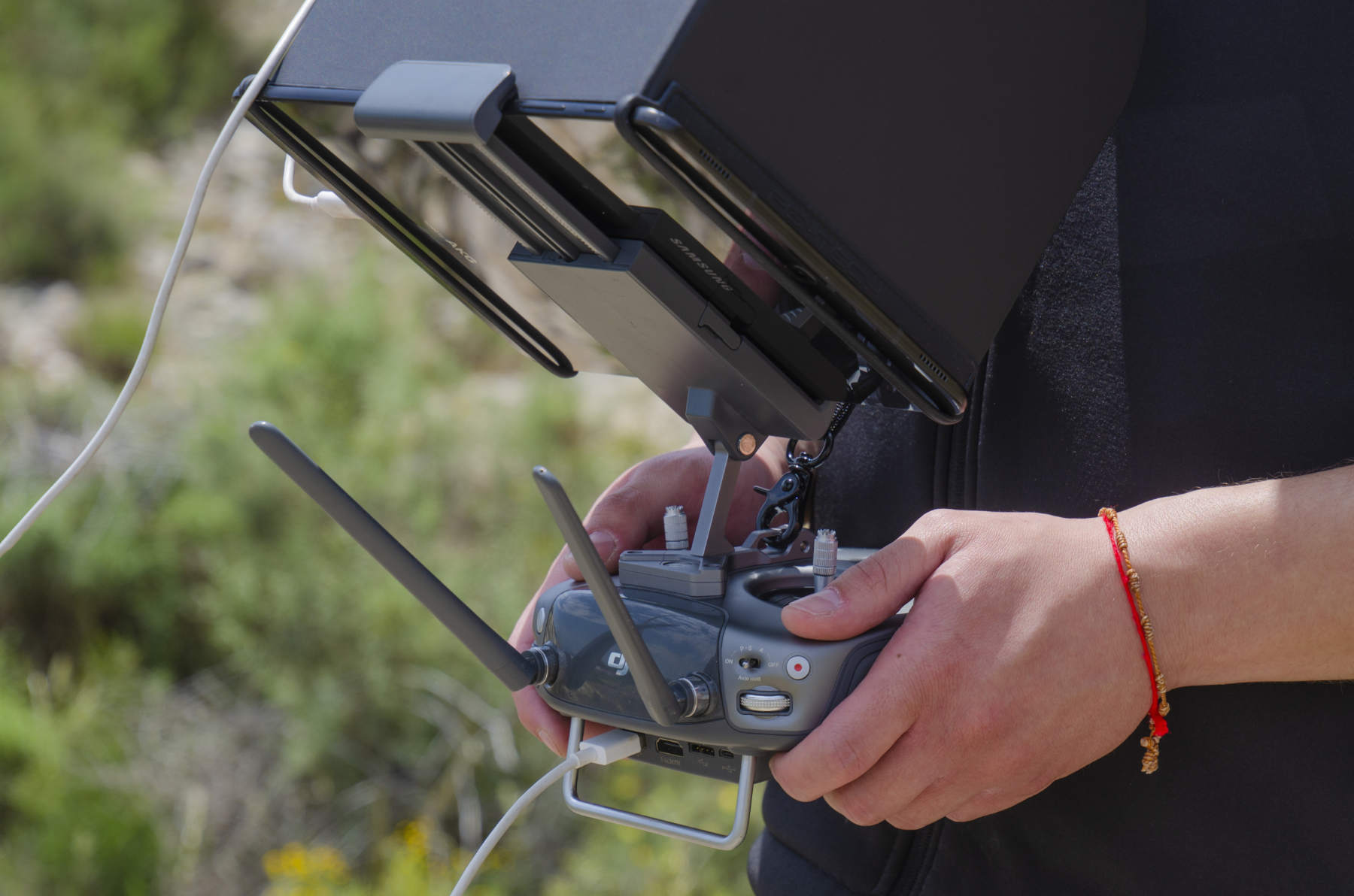 Manos del piloto sobre la emisora con la tablet de control