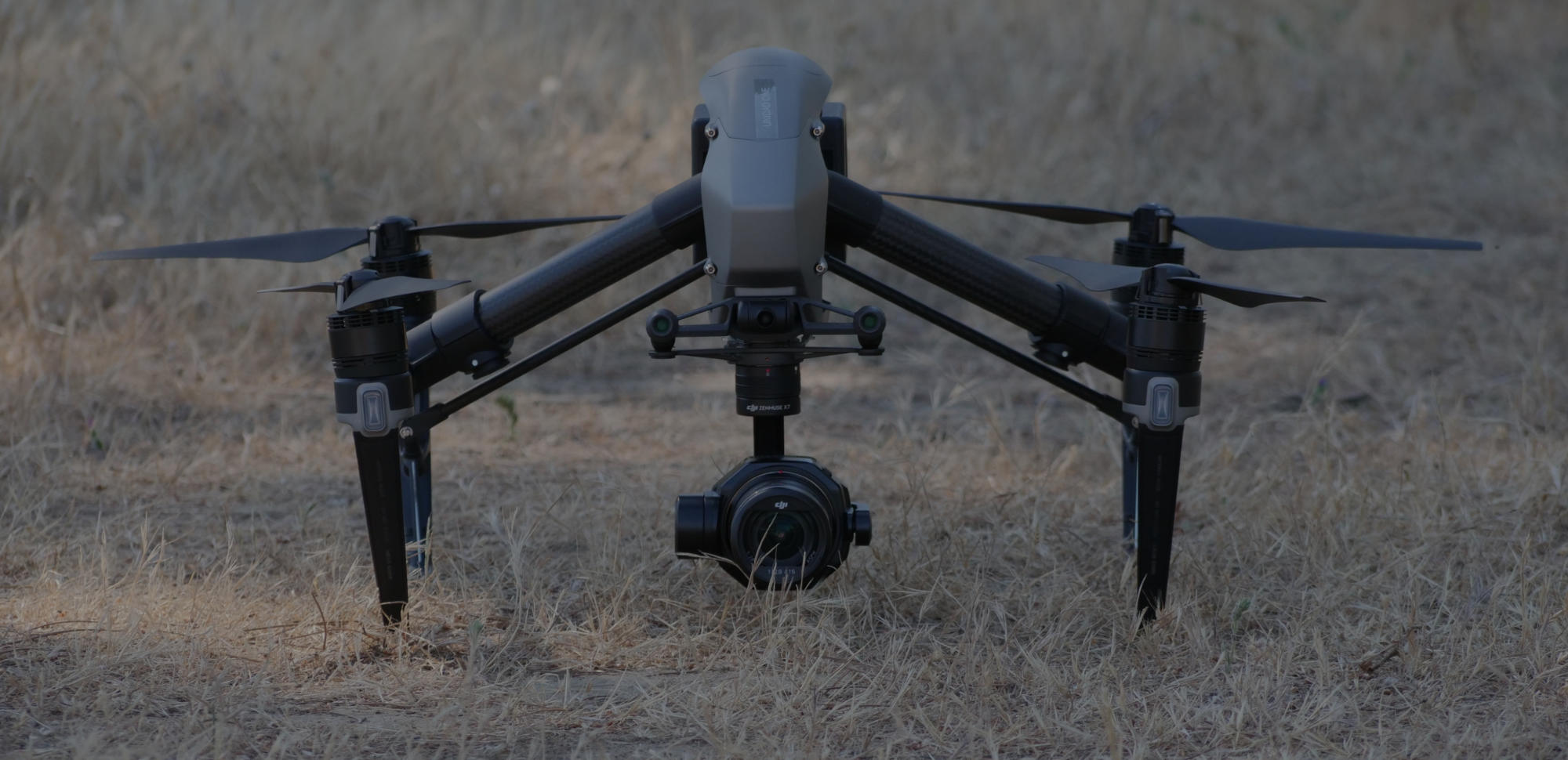 Dron posado en el suelo, preparado para despegar en campo abierto