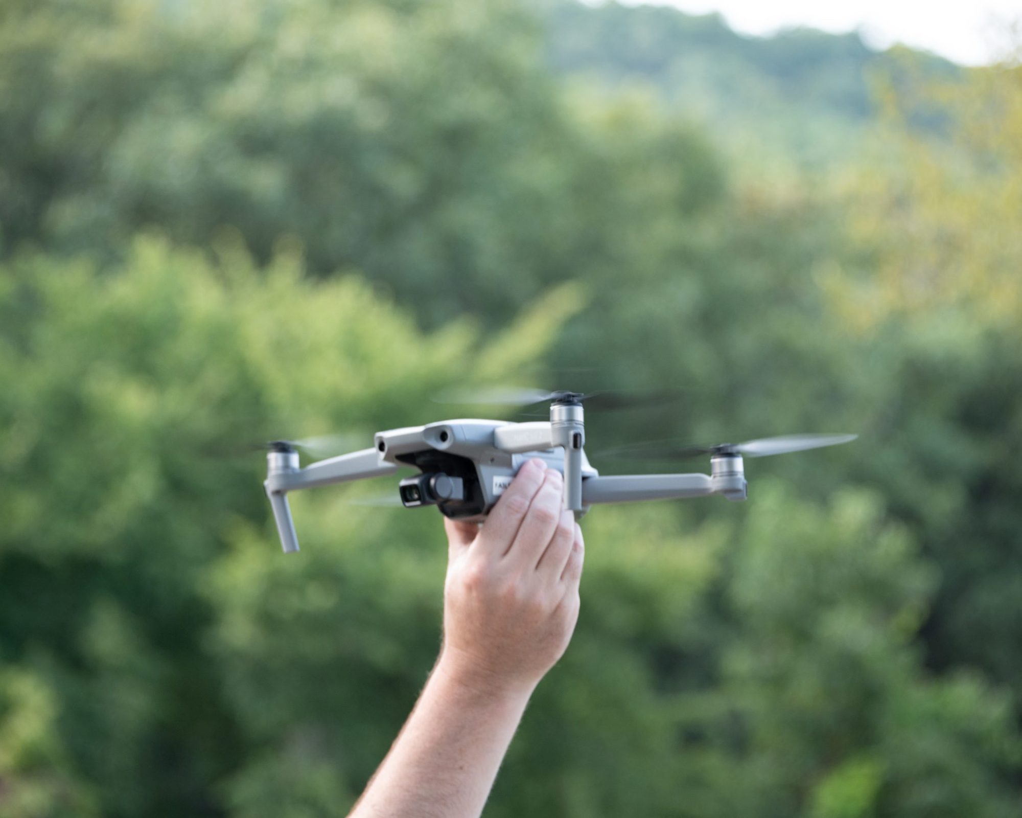 Mano sujetando un dron plegable antes de despegar