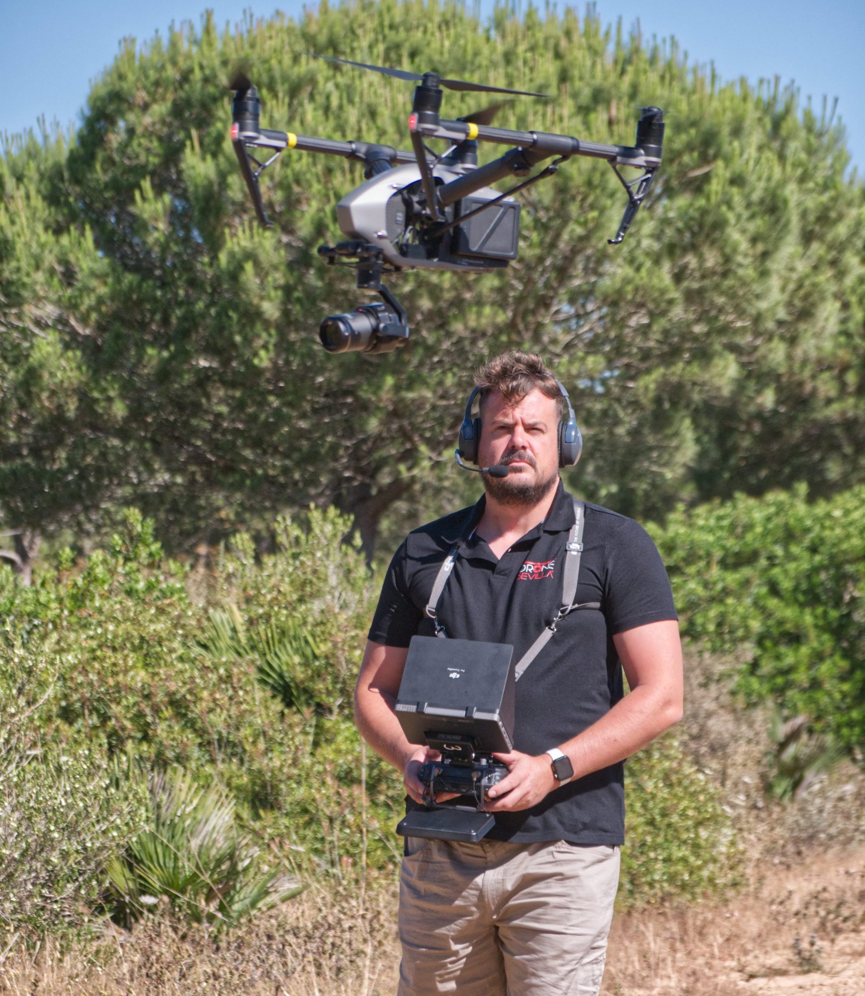 Piloto operando un dron en vuelo en terreno de monte